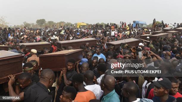 Pall bearers carry coffins during the funeral service for people killed during clashes between cattle herders and farmers, on January 11 in Ibrahim...