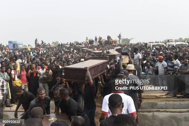 Pall bearers carry coffins during the funeral service for people killed during clashes between cattle herders and farmers, on January 11 in Ibrahim...