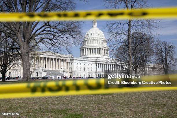 the capitol building stands behind caution tape - government shutdown - fotografias e filmes do acervo