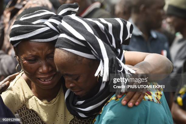 Woman cries while trying to console a woman who lost her husband during the funeral service for people killed during clashes between cattle herders...