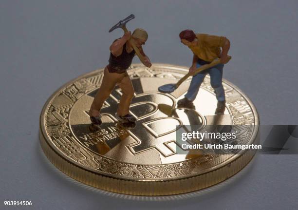 Fascination and uncertainty - Bitcoin. Symbol photo on the topic crypto currency Bitcoin. The picture shows Bitcoin and workers with a pickaxe and a...