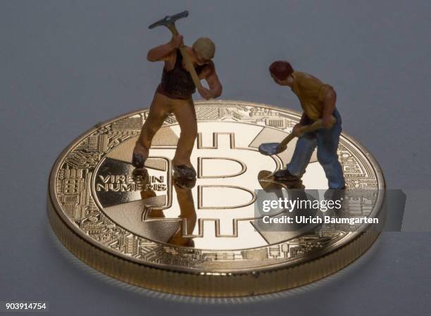 Fascination and uncertainty - Bitcoin. Symbol photo on the topic crypto currency Bitcoin. The picture shows Bitcoin and workers with a pickaxe and a...