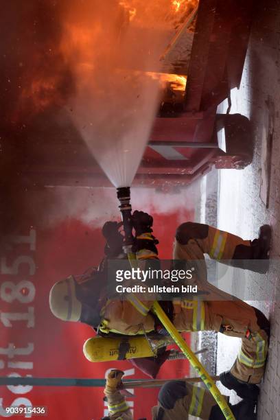 Angriffstrupp löscht während der jährlichen Weihnachtspressekonferenz der Berliner Feuerwehr mit einer Demonstration des richtigen Umgangs mit Kerzen...
