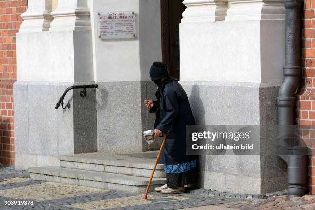 Alte Frau beim Betteln an der St.-Peter-und-Paul-Kathedrale in Poznan - Polen