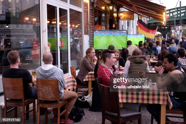 Fußballfans verfolgen das Eröffnungsspiel Frankreich gegen Rumänien anlässlich der Fußball-Europameisterschaft 2016 im Freisitz einer Bar in...