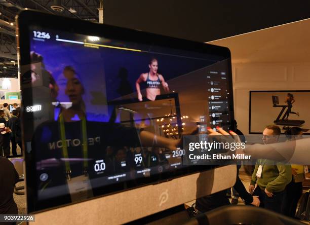 Maggie Lu is reflected in a touch screen as she demonstrates how to select a class on a Peloton Tread treadmill during CES 2018 at the Las Vegas...