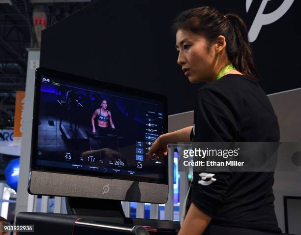 Maggie Lu demonstrates how to select a class on a touch screen of a Peloton Tread treadmill during CES 2018 at the Las Vegas Convention Center on...