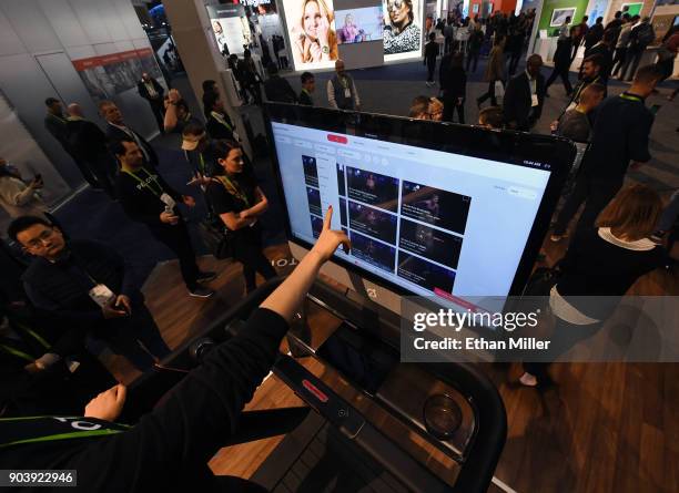 Maggie Lu demonstrates how to select a class on a touch screen of a Peloton Tread treadmill during CES 2018 at the Las Vegas Convention Center on...