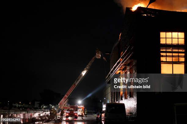Berliner Feuerwehr bei Löscharbeiten einer brennenden Lagerhalle mit einer Autowerkstatt an der Strasse am Wasserwerk in Berlin Lichtenberg unweit...