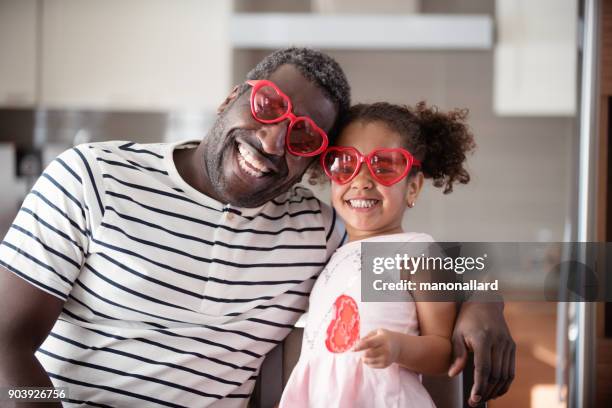 gemischte rassen vater und tochter geschmack lollipop während valentinstag - mixed race family stock-fotos und bilder