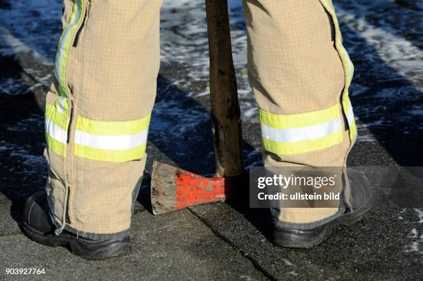 Feuerwehrmann mit Feuerwehraxt bei Löscharbeiten in Berlin