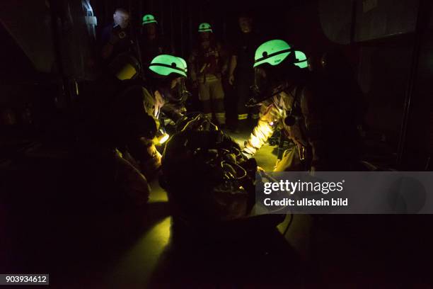 Fluoreszierende Feuerwehrhelme leuchten bei einer Übung der Atemschutznotfall trainierten Staffel der Feuerwache 1300 in den dunklen...