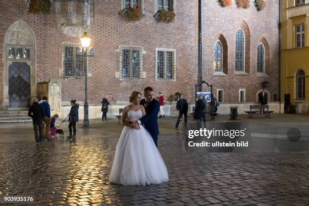 Brautpaar läßt sich nachts auf dem Rynek in der Altstadt von Wroclaw/Breslau fotografieren