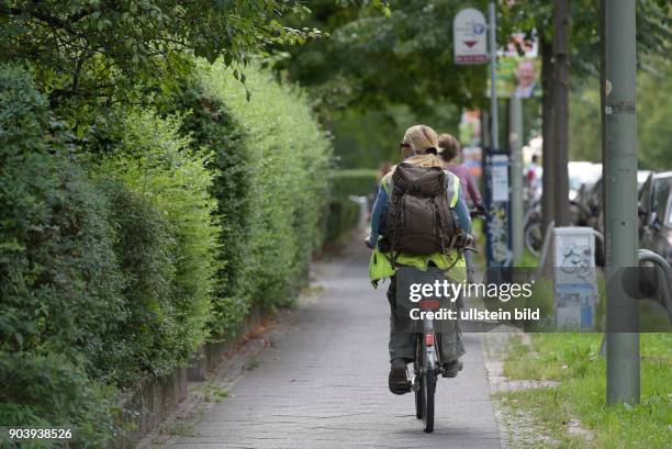 Fahrradfahrer unterwegs auf dem Gehweg auf der Wisbyer Straße in Berlin-Prenzlauer Berg