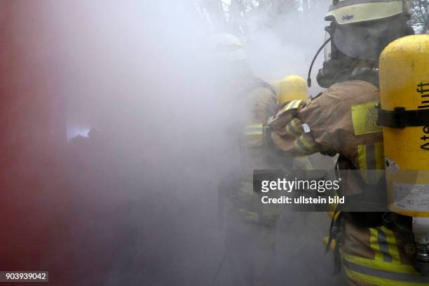 Feuerwehrleute der Atemschutznotfall-Trainierten-Staffel beim Betreten der bis auf Nullsicht vernebelten Such- und Rettungsarena der Berliner...