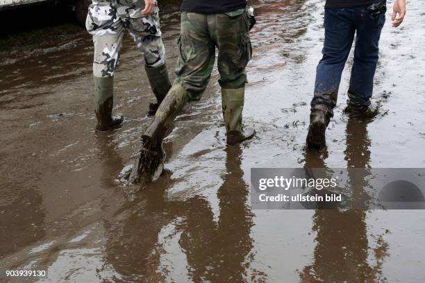 Heavymetal-Fans waten durch Schlamm und tiefe Regenpfützen während des Wacken-Open-Air Festivals 2016