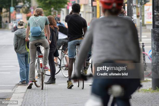 Fahrradfahrer warten an der Kreuzung Schönhauser Allee / Wibyer Straße in Berlin-Prenzlauer Berg