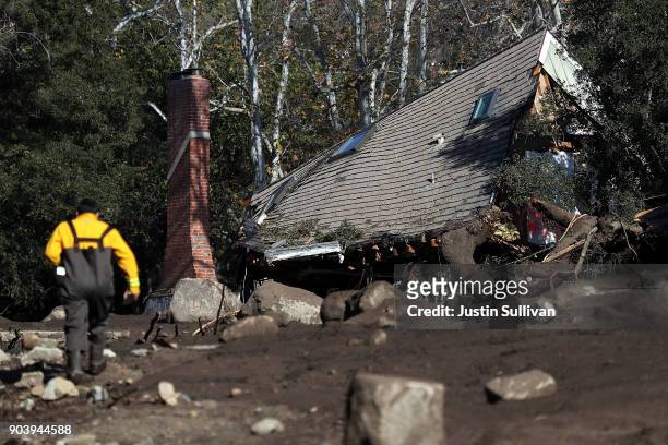Home that was destroyed by a mudslide sits on its side in a field of debris on January 11, 2018 in Montecito, California. 17 people have died and...