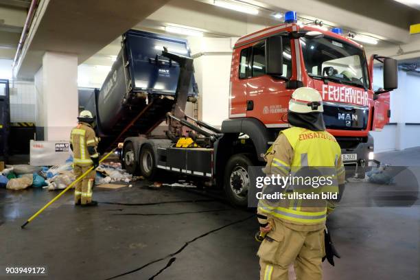 Feuerwehr bei einem Löscheinsatz bei einem Schwelbrand in einem großen Müllcontainer in Ladebereich eines Berliner Einkaufszentrums in...
