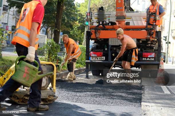 Arbeiter beim Ausbessern der Fahrbahn in der Wichertstrasse in Berlin-Prenzlauer Berg