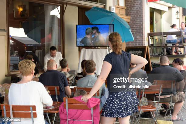 Fußballfans verfolgen das Spiel Deutschland-Slowakei anlässlich der Fußball-Europameisterschaft 2016 vor einem Restaurant in der Kastanienallee in...