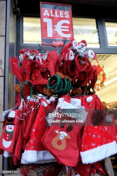 Rote Weihnachtsmützen stehen an einem Geschäft in Berlin-Prenzlauer Berg zum Verkauf