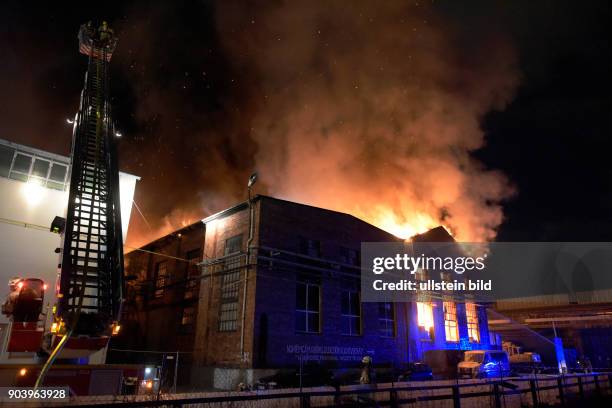 Berliner Feuerwehr bei Löscharbeiten einer brennenden Lagerhalle mit einer Autowerkstatt an der Strasse am Wasserwerk in Berlin Lichtenberg unweit...