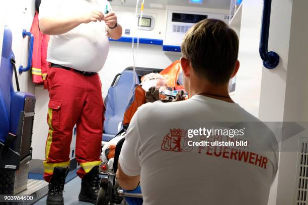 Patient wird von Rettungsassistenten der Berliner Feuerwehr auf einem Rettungswagen erstversorgt