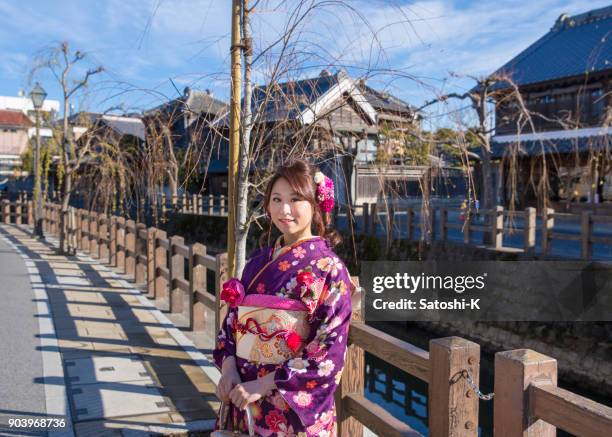 young woman in furisode kimono in traditional japanese town - seijin no hi stock pictures, royalty-free photos & images