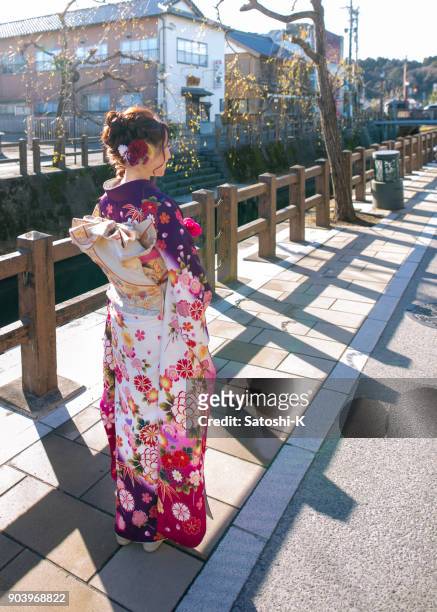 young woman in furisode kimono in traditional japanese town - seijin no hi stock pictures, royalty-free photos & images