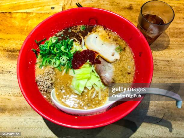 spicy miso ramen served in red bowl on table - miso ramen stock pictures, royalty-free photos & images