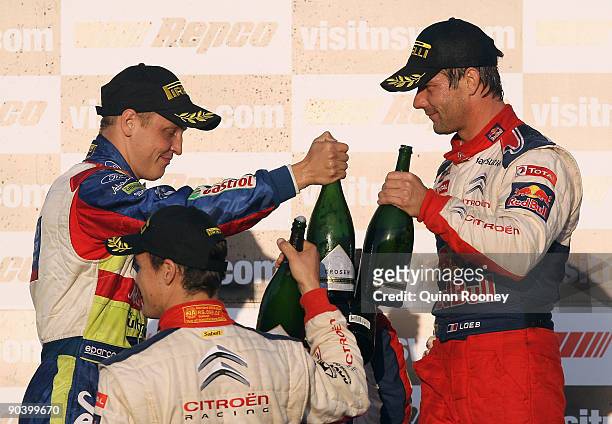 Sebastien Loeb of France and the Citroen C4 Total team and Mikko Hirvonen of Finland and the BP Abu Dhabi Ford Focus team celebrate on the podium...