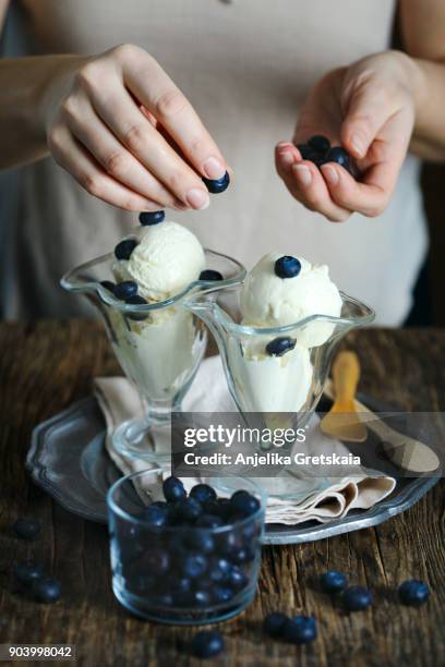 woman serving ice cream in glass cup - cream horn stock-fotos und bilder