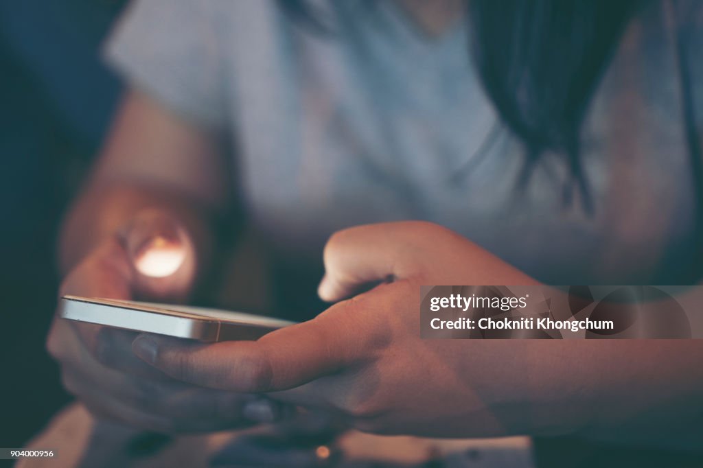 Midsection Of Woman Using Phone In Darkroom