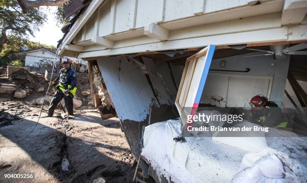 Ventura County fire captain Clay Cundiff, right, and captain Scott Sato, left, search in and around a home for a woman who was reported missing by...