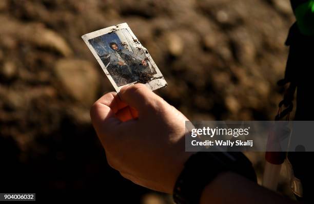 Member of the San Bernardino Search and Rescue holds a picture that was found along the East Cold Springs Creek in Montecito after a major storm hit...