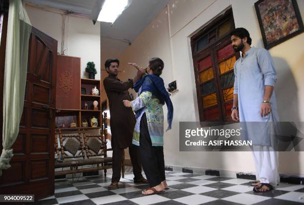 This photograph taken on October 18 shows Pakistani actress Rubina Ashraf and actors Ali Abbas and Imran Ashraf taking part in the filming of a scene...