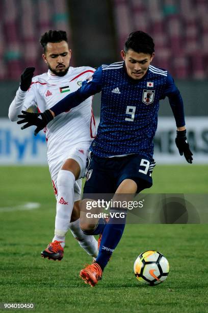 Kyosuke Tagawa of Japan and Omar Sandouqa of Palestine compete for the ball during the AFC U-23 Championship Group B match between Japan and...