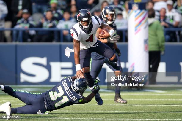 Deshaun Watson of the Houston Texans leaps over Kam Chancellor during the game against the Seattle Seahawks at CenturyLink Field on October 29, 2017...