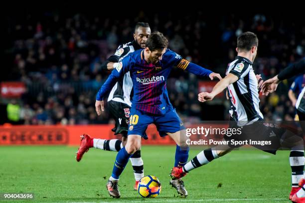 Lionel Andres Messi of FC Barcelona fights for the ball with Sergio Postigo Redondo and Cheik Doukoure of Levante UD during the La Liga 2017-18 match...