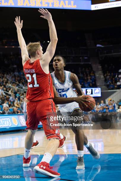 Bruins guard Kris Wilkes drives into the basket against Utah Utes forward Tyler Rawson during the game between the Utah Utes and the UCLA Bruines on...
