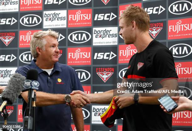 Michael Hurley of the Bombers presents with David Rogers, CEO of Challenge with a jumper from the 2017 Clash for Cancer match during the Essendon...