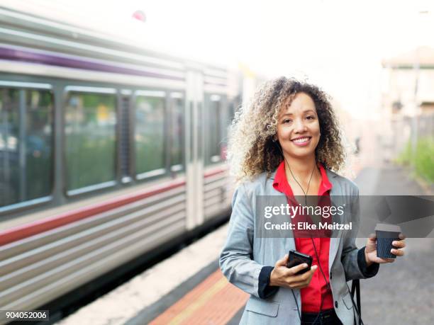 woman standing on train platform - electronic listening device stock pictures, royalty-free photos & images