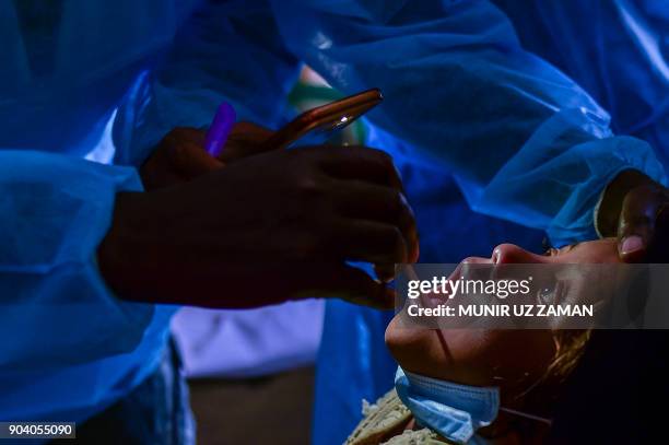 In this photograph taken on January 10 doctors from Médecins Sans Frontières examine Rohingya Muslim refugee Mohammad Rashed and who is infected with...