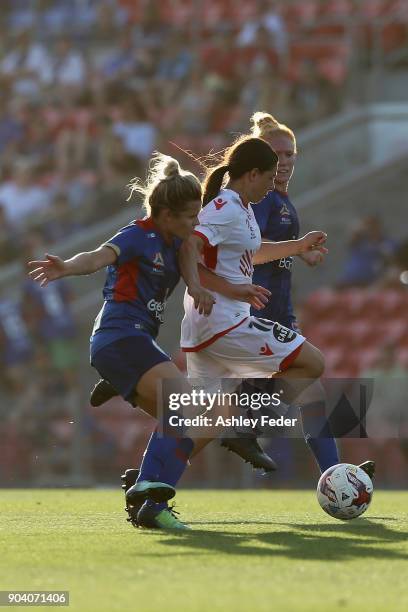 Alexandra Chidiac of Adelaide United runs the ball ahead of Cassidy Davis and Victoria Huster during the round 11 W-League match between the...