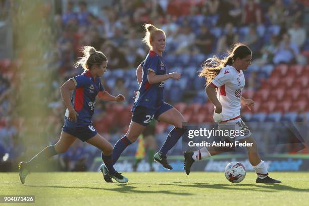 Alexandra Chidiac of Adelaide United runs the ball ahead of Cassidy Davis and Victoria Huster during the round 11 W-League match between the...