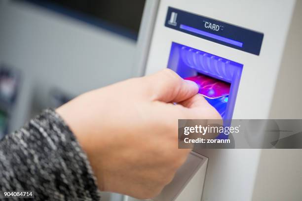 senior woman inserting credit card in atm machine - paid absence stock pictures, royalty-free photos & images