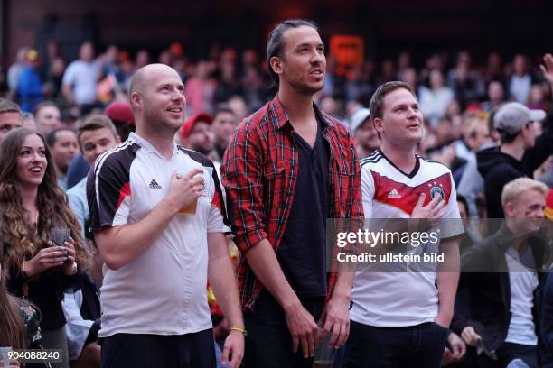 Deutsche Fussballfans beim Mitsingen der Nationalhymne beim Public Viewing in der Kulturbrauerei in Berlin-Prenzlauer Berg anlässlich der...