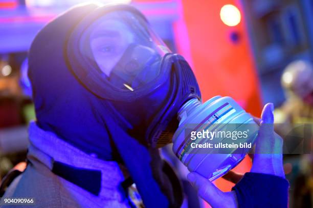 Feuerwehrmann rüstet sich während eines Wohnungsbrandes in der Bornholmer Strasse in Berlin-Prenzlauer Berg mit Atemschutzmaske und einem...