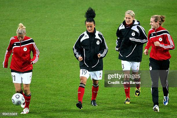 Anja Mittag, Fatmire Bajramaj, Saskia Bartusiak and Simone Laudehr warm up during a German National Team training session at the Helsinki football...